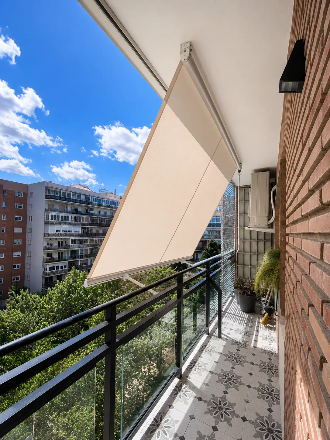 Toldo de brazos extensibles en un balcón de un edificio de Madrid