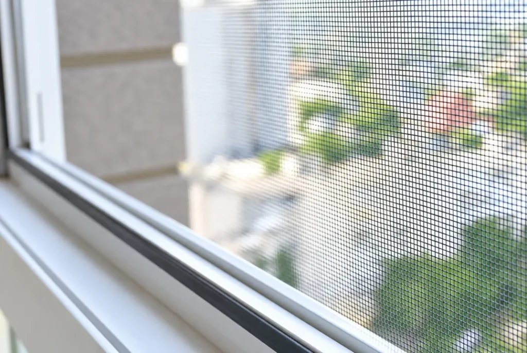 Detalle de la malla de una mosquitera en una ventana