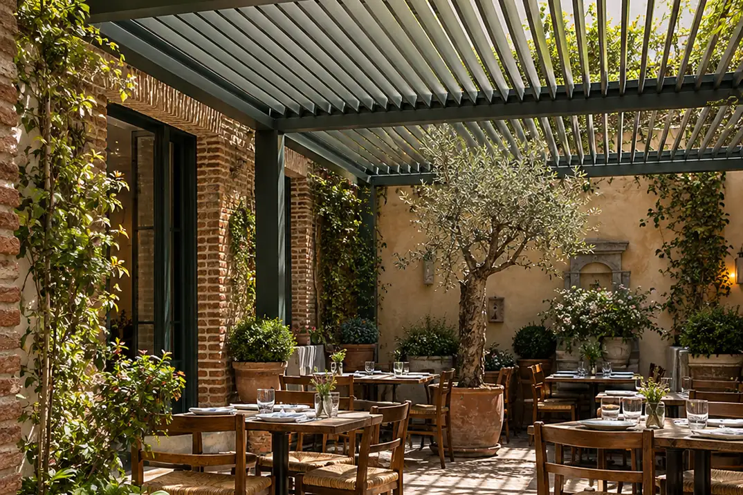 Pérgola bioclimática sobre una terraza con comedor, olivo y plantas trepadoras