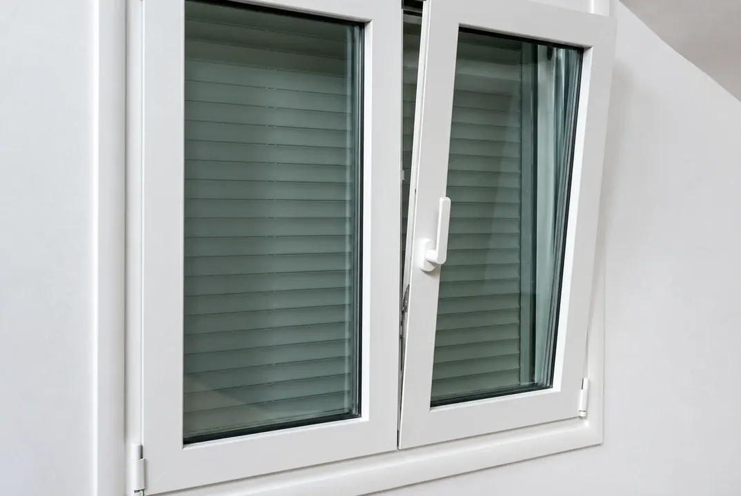 Persiana de PVC verde en una ventana abatible
