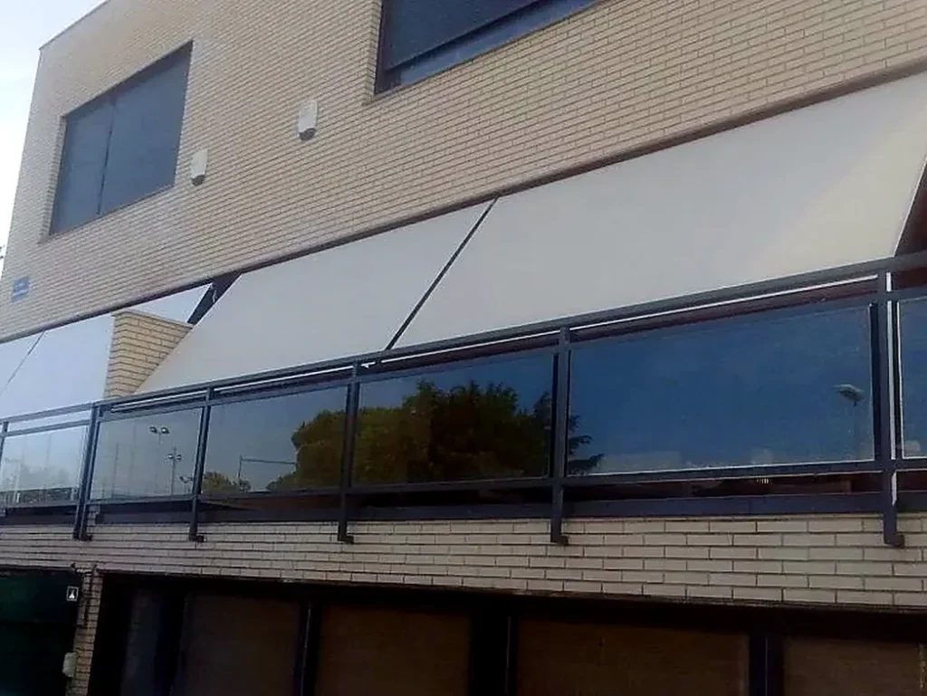 Toldos para terrazas en Madrid: toldo extensible sobre terraza con barandilla de cristal