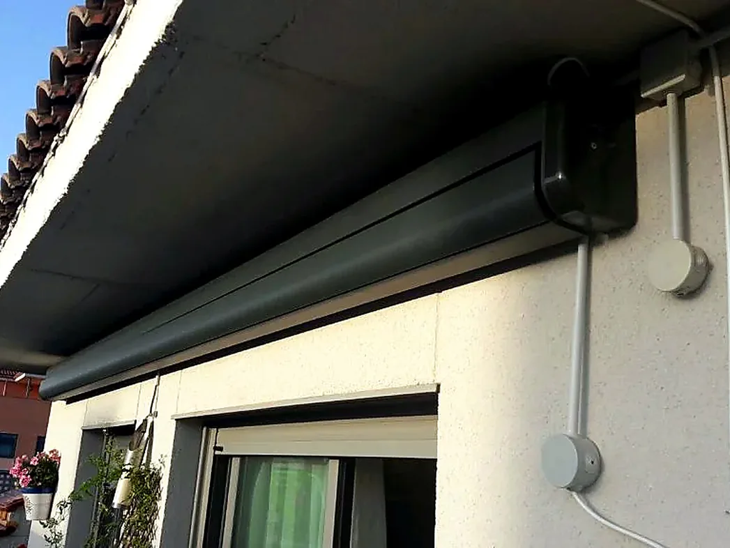 Toldos para terrazas en Madrid: cofre de toldo gris oscuro recogido en fachada