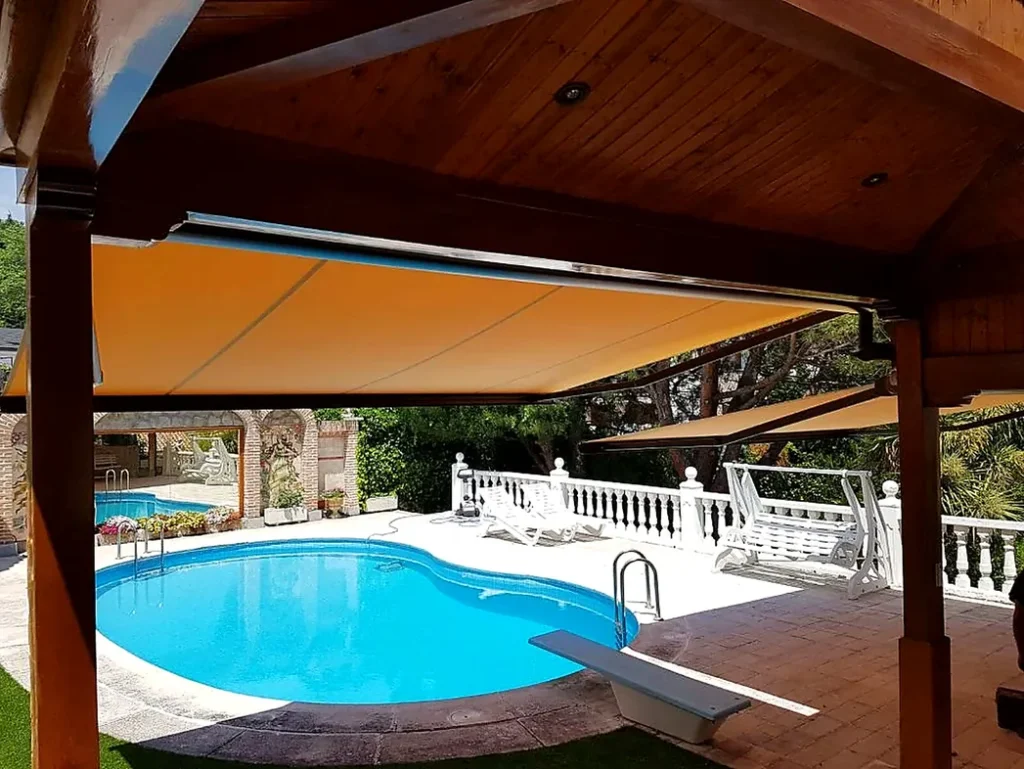 Toldos para terrazas en Madrid: toldo naranja bajo pérgola de madera junto a piscina