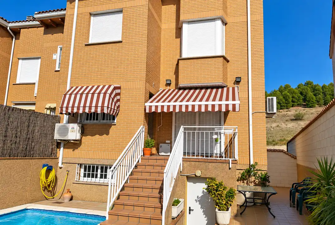 Toldo capota para terrazas y accesos en Madrid: capota de rayas granate y blancas sobre ventana de vivienda