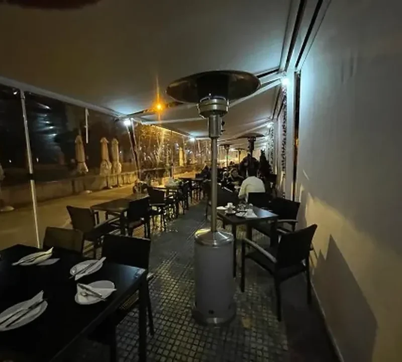 Terraza de restaurante cerrada con cerramiento transparente al anochecer